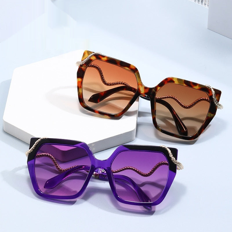 Two pairs of sunglasses with different colored lenses on a light blue background