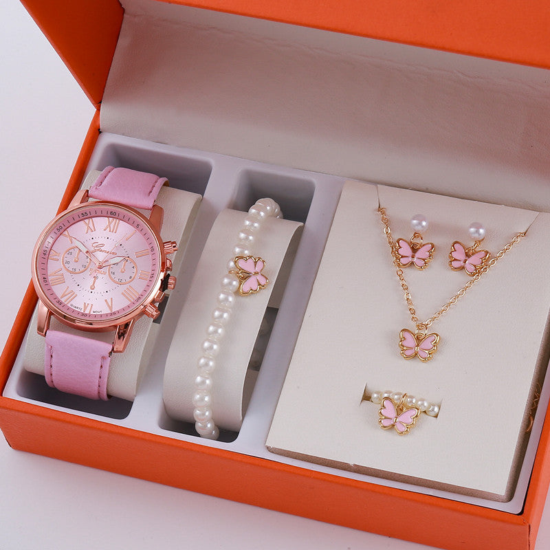 Jewelry set with pink watch, bracelet, and butterfly-themed necklace and earrings in an orange box.