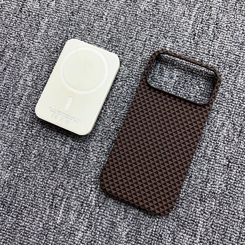 Brown textured phone case and white circular object on a gray textured surface