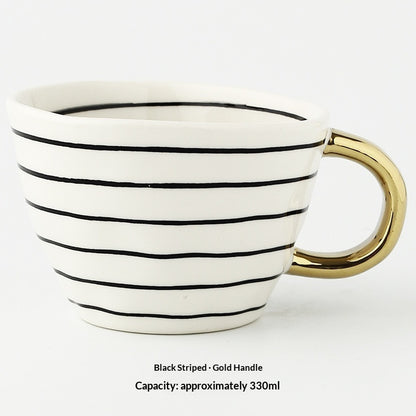 White mug with black stripes and a gold handle on a white background