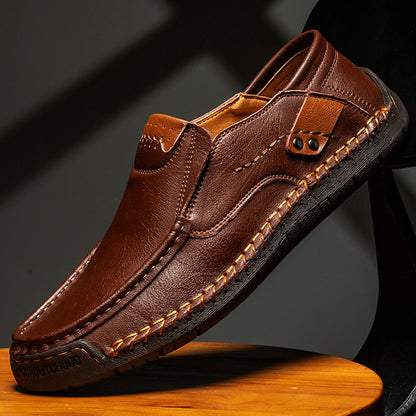 Brown leather loafer shoe on a wooden stool with a dark background