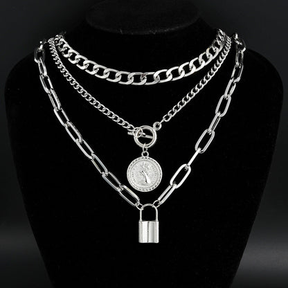 Silver chain necklace with padlock and round pendant on a black stand