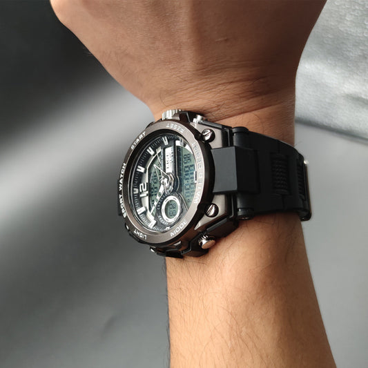 Black digital wristwatch on a person's wrist with a blurred background