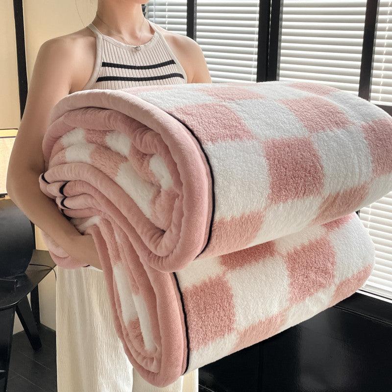 Person holding a pink and white checkered blanket indoors.