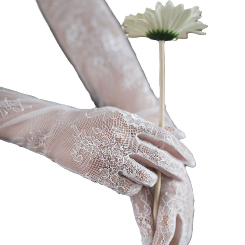 White lace gloves holding a white flower on a white background