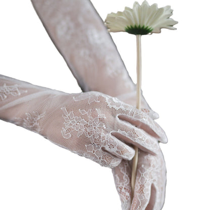White lace gloves holding a white flower on a white background