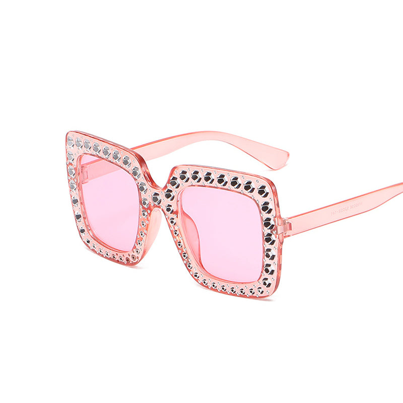 Pink sunglasses with decorative frame on a white background