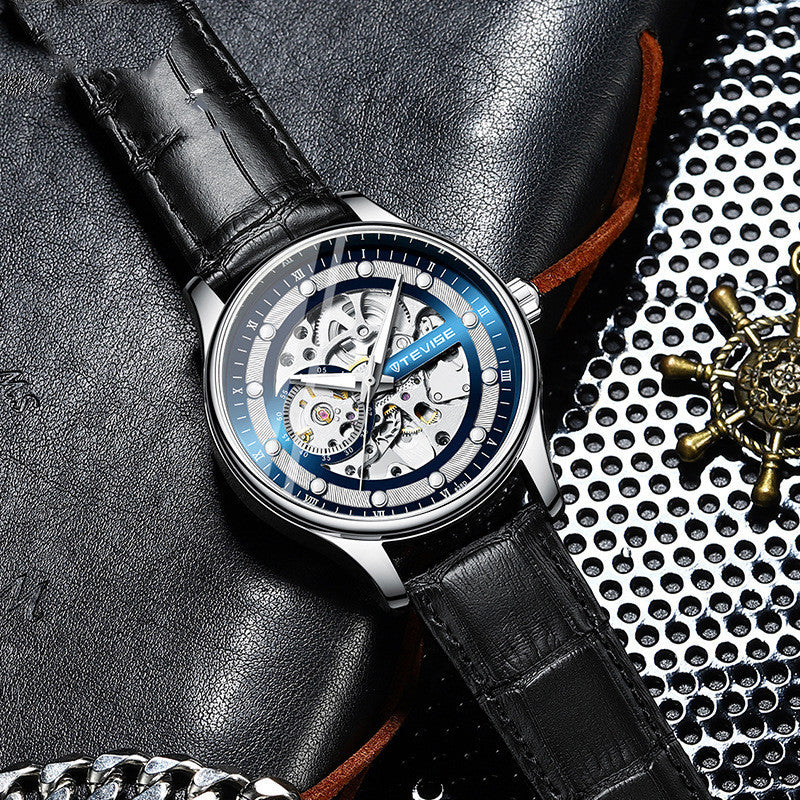 Watch with black leather strap on textured surface
