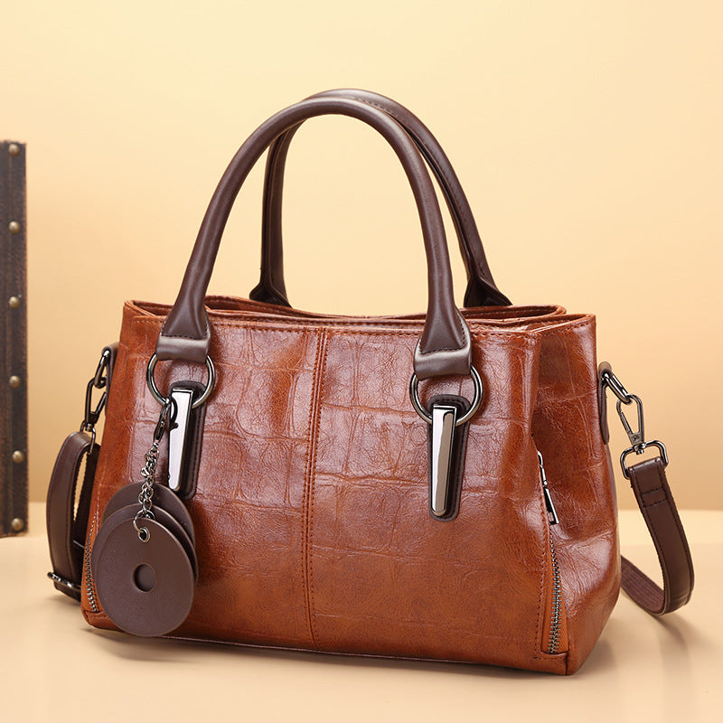 Brown leather-look large-capacity handbag with twin top handles, metal clasps, and side straps