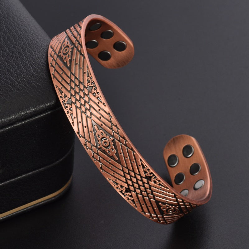 Copper bracelet with intricate patterns on a dark background