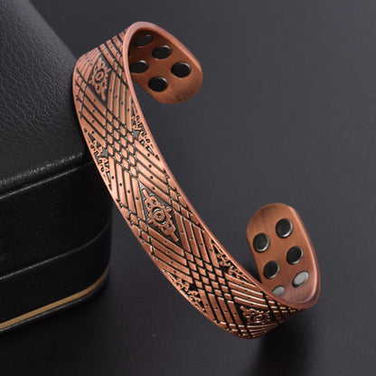 Copper bracelet with intricate patterns on a dark background