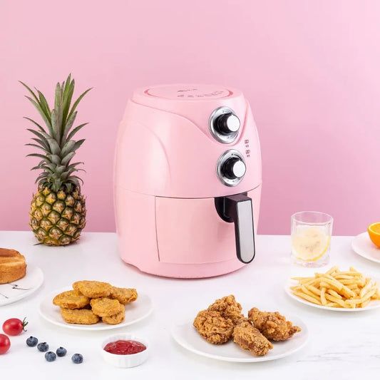 Pink air fryer on a table with plates of food against a pink background