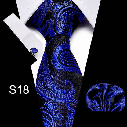 Blue paisley tie set with pocket square and cufflinks on a black and white background