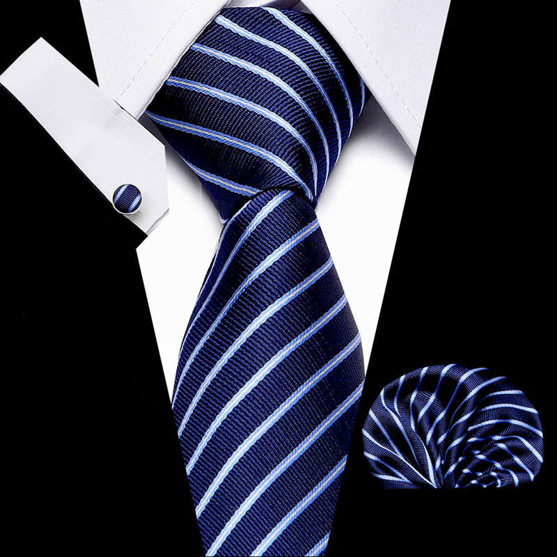 Navy blue and white striped tie with matching pocket square and cufflinks on a black background.