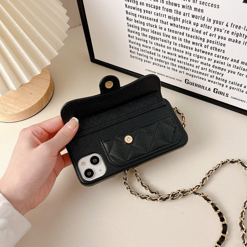 Quilted black phone crossbody case with gold chain strap, front view in hand