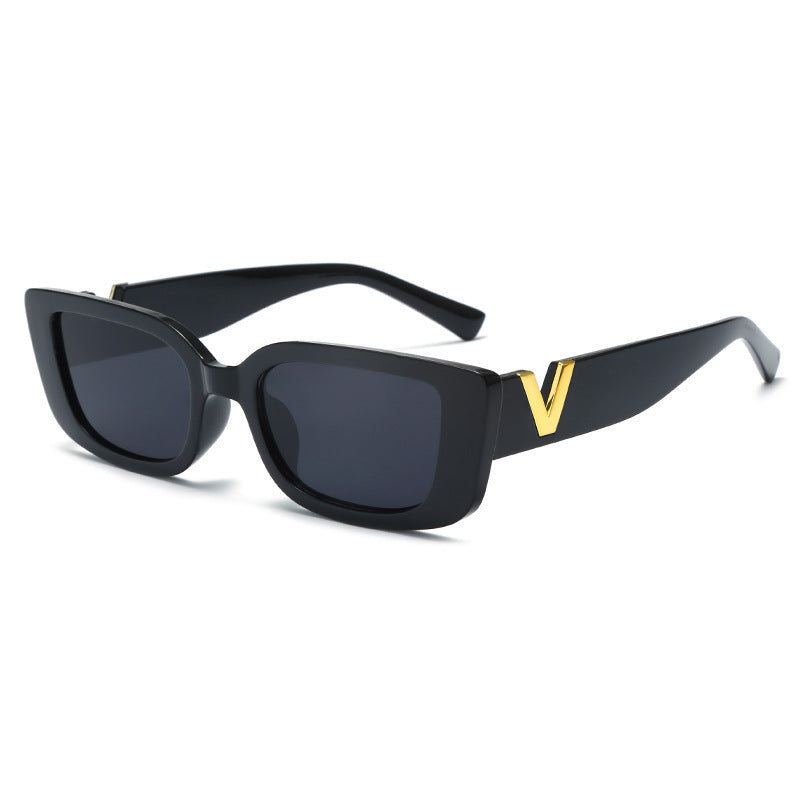 Black sunglasses with a gold 'V' on a white background