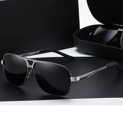 Sunglasses with gunmetal frame and gray lenses on a black surface.