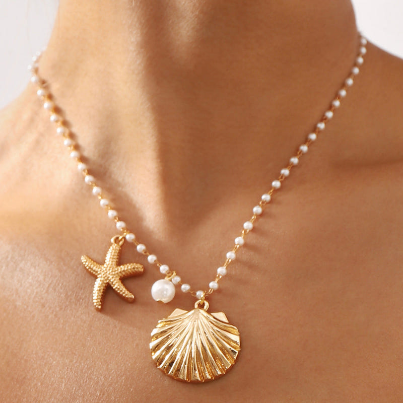 Gold-tone pearl necklace with starfish and seashell charms, bead link chain
