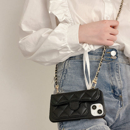 Quilted black phone crossbody case with gold chain strap, worn with denim