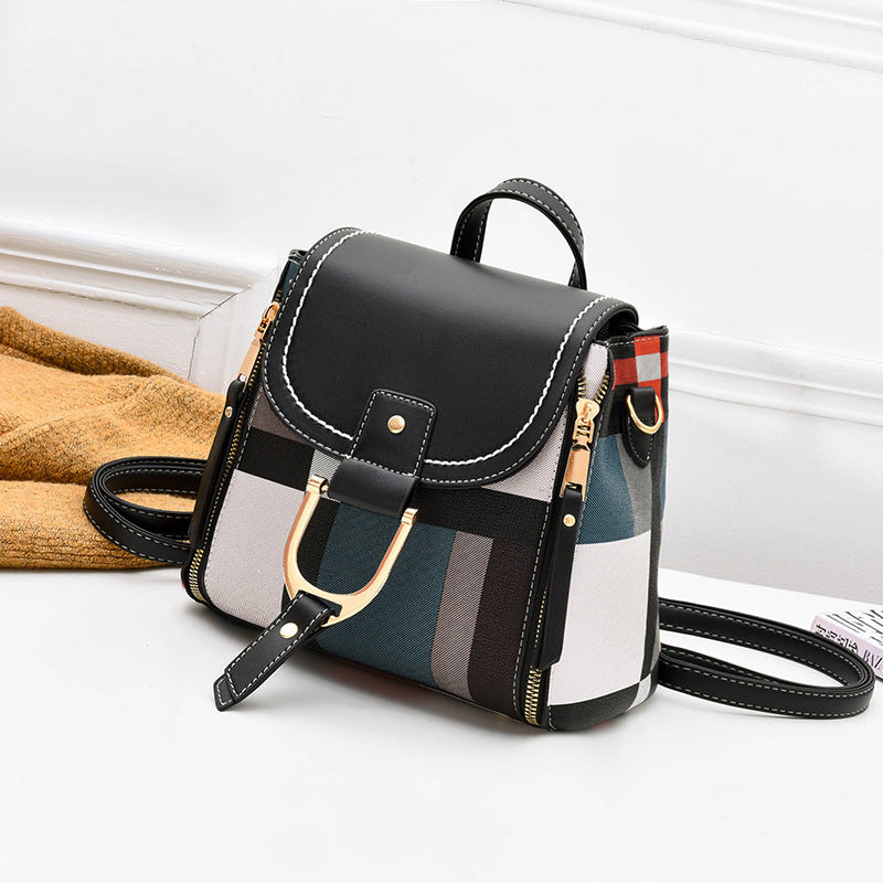 Black plaid crossbody bag with top flap, buckle belt, and side zip pocket