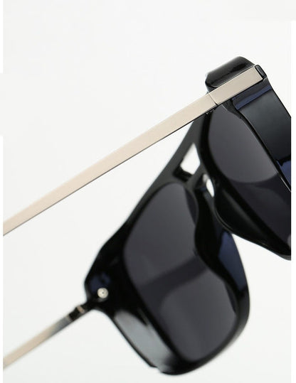 Side view of black sunglasses with dark lens and light tan temples