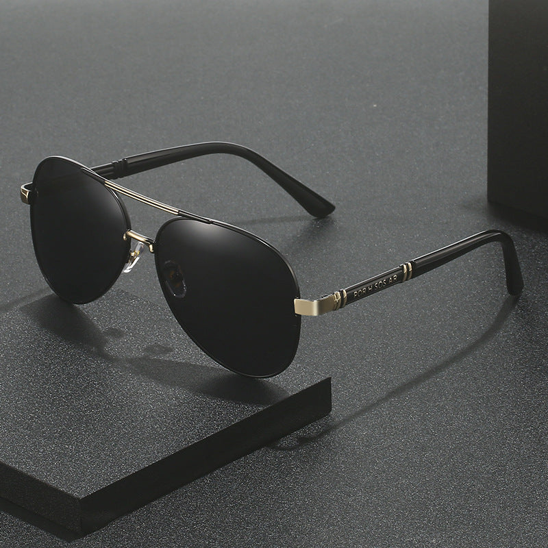 Black sunglasses with gold accents on a gray background