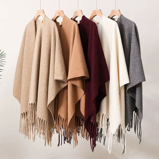 Set of five different colored scarves with fringes on hangers against a white background