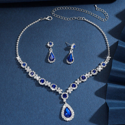 Silver bridal jewelry set with blue crystal drop necklace, earrings, and chain bracelet