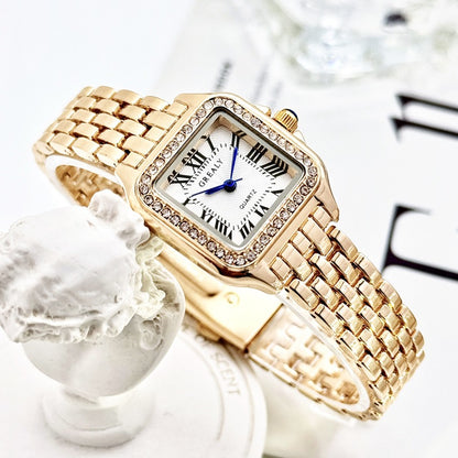 Gold wristwatch with a white face and Roman numerals on a decorative background