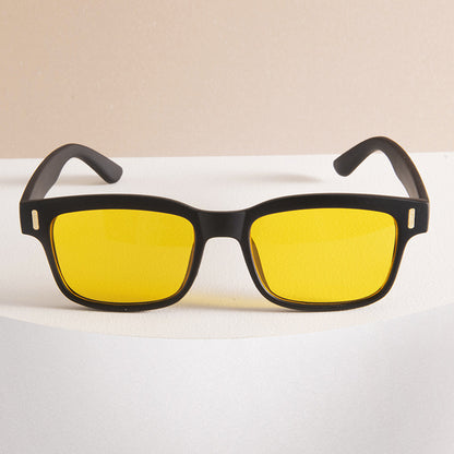 Sunglasses with black frames and yellow lenses on a white surface.