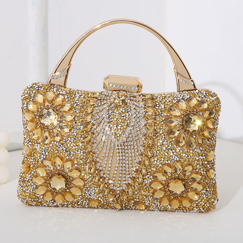 Gold handbag with floral embellishments on a white background