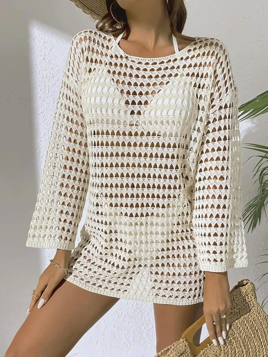 Woman wearing a white crochet dress with long sleeves against a neutral background