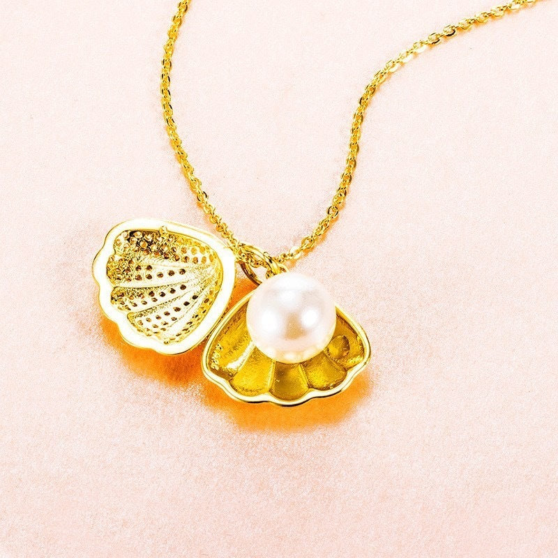 Women's Gold necklace with a shell and pearl pendant on a light pink background