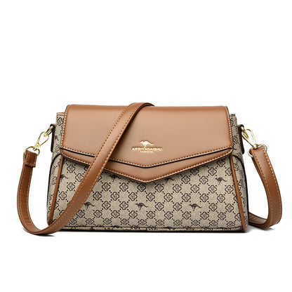 Brown handbag with patterned flap and matching strap on a white background