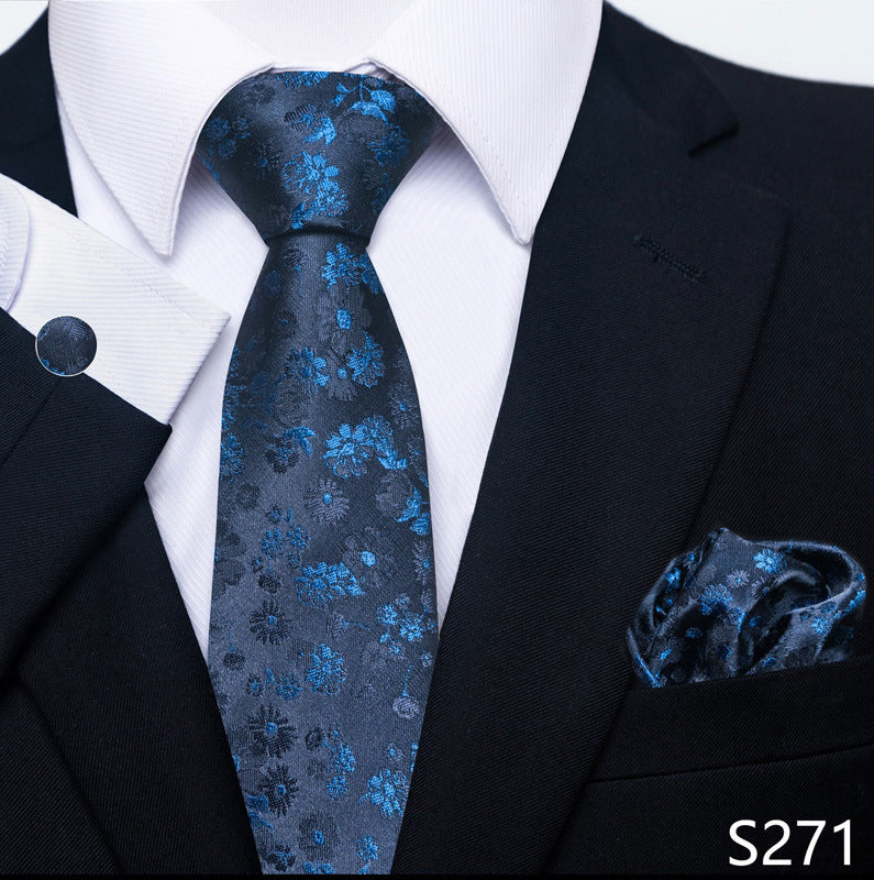 Black suit with a blue floral tie and matching pocket square on a white background