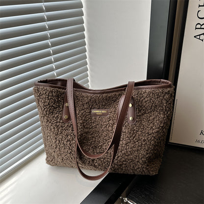 Brown furry tote shoulder bag with dual top handles and front logo patch