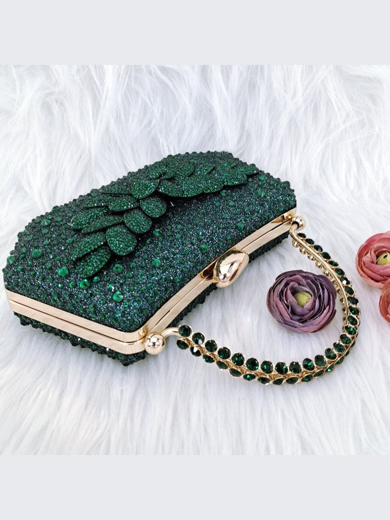 Green glittery handbag with floral design and gold chain on a white background