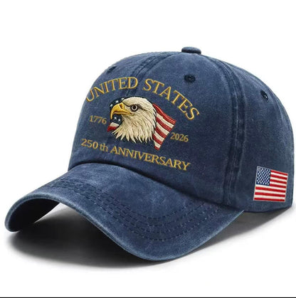 Navy blue washed-print cap with gold “United States 1776–2026” eagle graphic and flag patch.