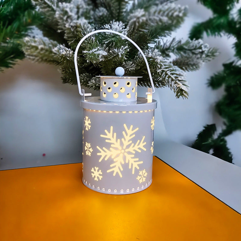 Decorative lantern with snowflake patterns on a table with a Christmas tree in the background