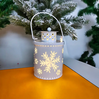 Decorative lantern with snowflake patterns on a table with a Christmas tree in the background