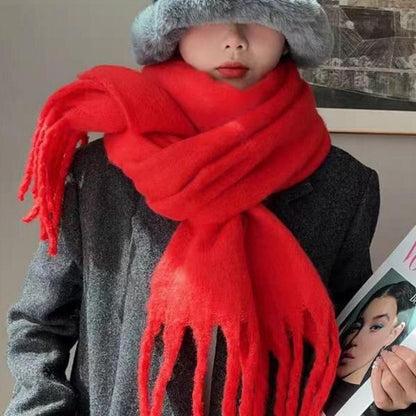 Person wearing a red scarf and gray hat with a magazine in the background