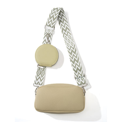 Beige crossbody bag with a patterned strap on a white background