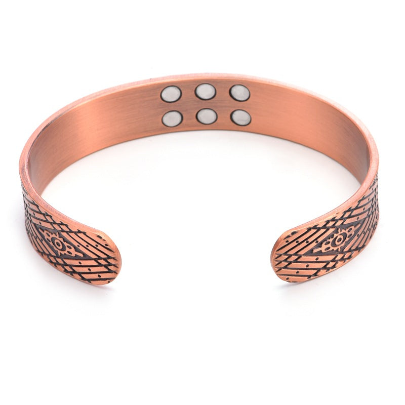 Copper bracelet with engraved patterns on a white background