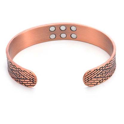 Copper bracelet with engraved patterns on a white background