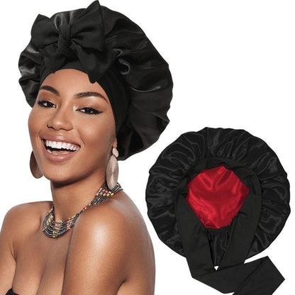 Satin ribbon round cap in black satin, heart accent on the side and bow