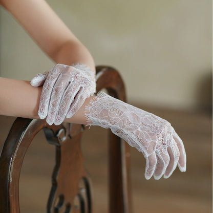 White lace gloves being worn on a blurred background