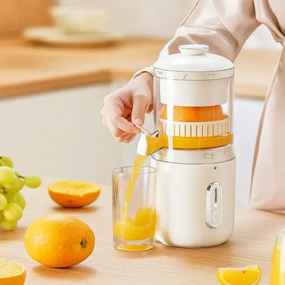 White portable electric juicer with pitcher spout and orange juice in glass